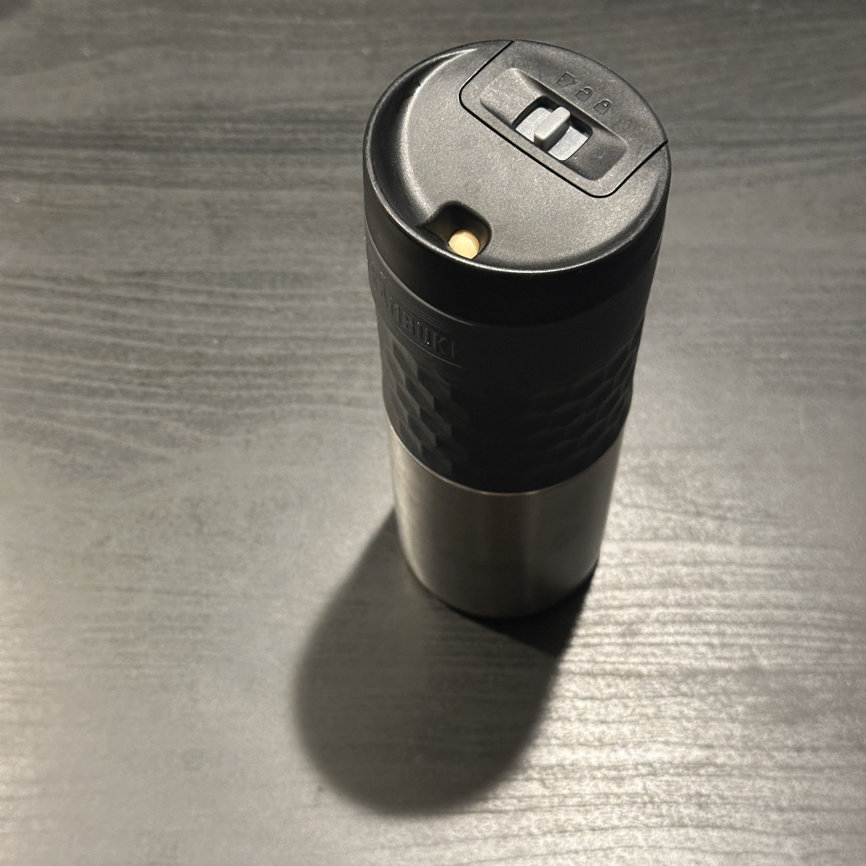 A travel mug lid that displays when the cap is twisted on tightly through an LED & slide-switch
